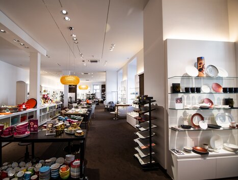 Un design di negozio moderno con articoli da tavola colorati e oggetti decorativi. | © Klammerth