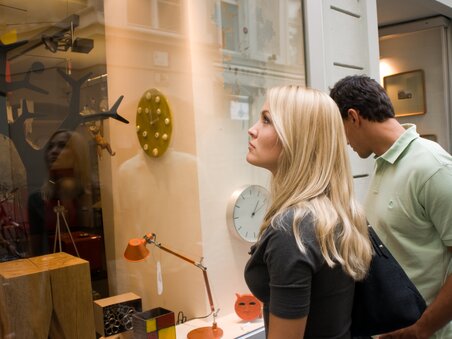 Zwei Personen betrachten das Schaufenster des MuR Design Stores in Graz. | © Graz Tourismus - Hans Wiesenhofer