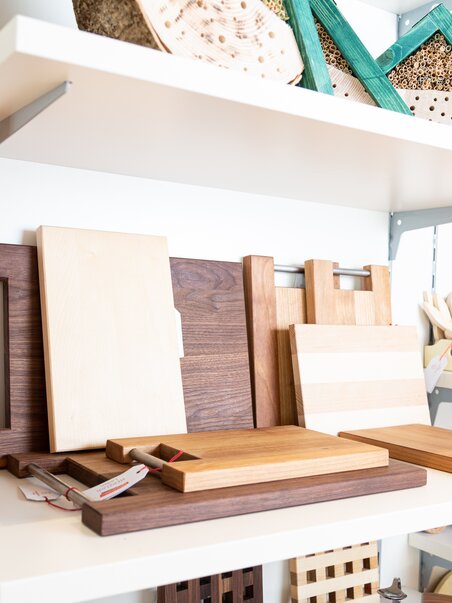 Eine Auswahl an Holzschneidebrettern und Holzprodukten im HERZLich Laden. | © Willi Moertl