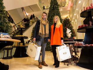 Couple with shopping bags in a festively decorated store. | © Harry Schiffer
