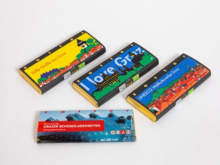 Barrette di cioccolato con motivi di Graz, come "I love Graz" e Patrimonio Mondiale dell'UNESCO. | © Graz Tourismus - Harry Schiffer