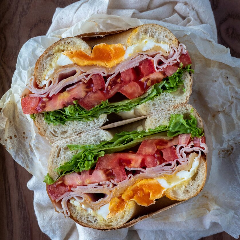 Bagel con prosciutto, uova, pomodori e insalata. | © Foto von Vicky Ng auf Unsplash