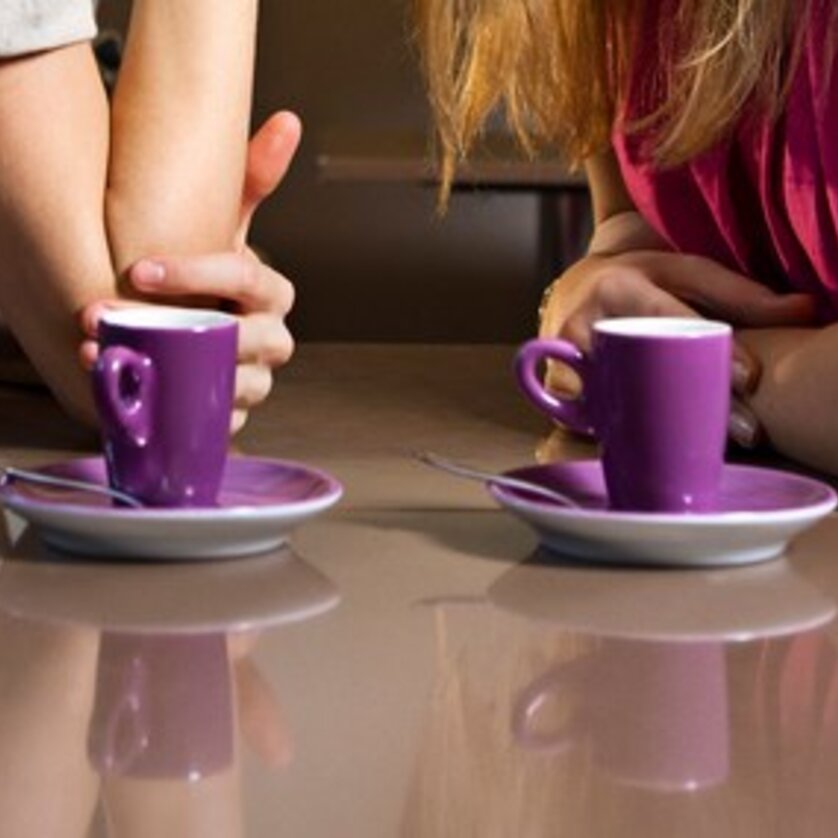 Caffè a Graz | © Graz Tourismus - Toni Muhr Due piccole tazze di caffè viola su un tavolo, mani si intrecciano. | © Graz Tourismus - Toni Muhr