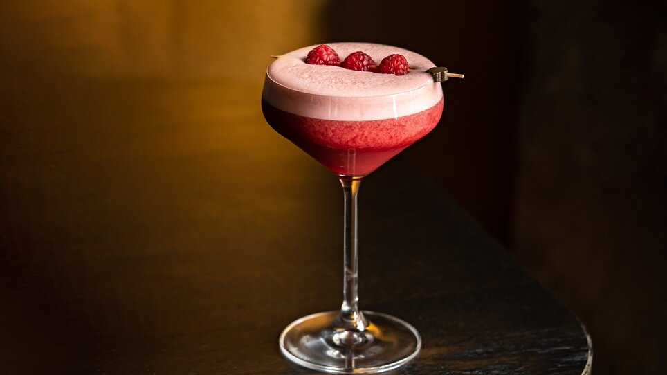 Cocktail con lamponi in un elegante bicchiere, servito in un bar alla moda. | © Lucija Novak