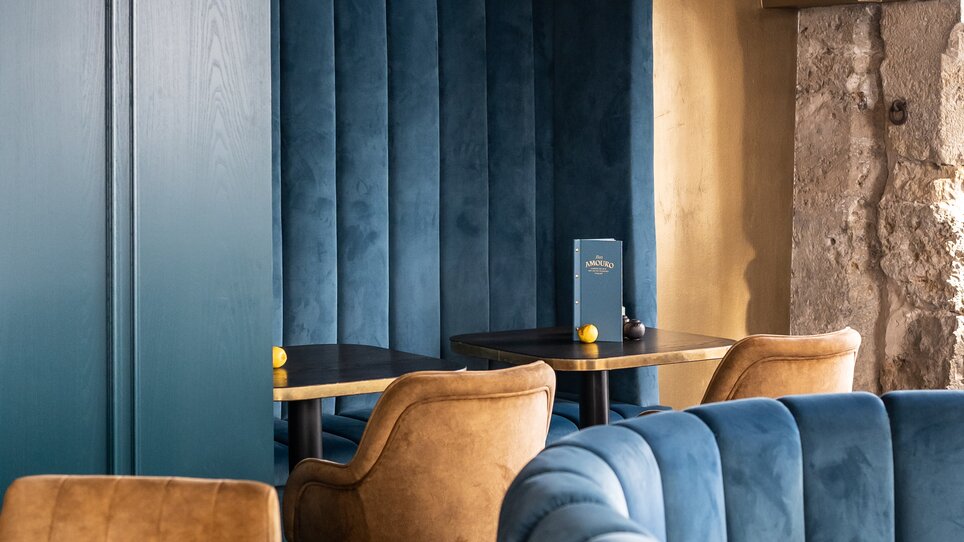 Posti a sedere accoglienti nel Bar Amouro con design blu. | © Lucija Novak