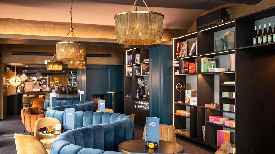 Bar accogliente con arredamento moderno a Graz, scaffali di libri e lampade stilose. | © Lucija Novak