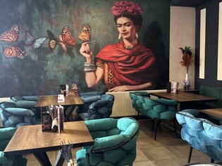 Interno artistico con murales e posti a sedere accoglienti. | © Bonbon