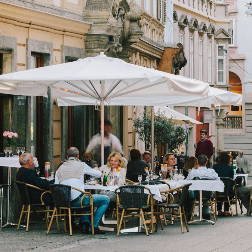 Lively restaurant terrace in Graz with guests and tables. | © Sebastian Reiser