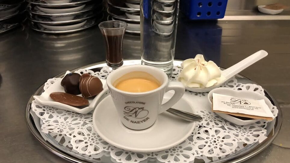 Tazza di espresso, dolci e acqua su un vassoio. | © Christian Kober