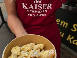 Eine Schüssel Kaiserschmarrn mit Zucker und Sauce in Graz. | © Der Kaiserschmarrn von Graz
