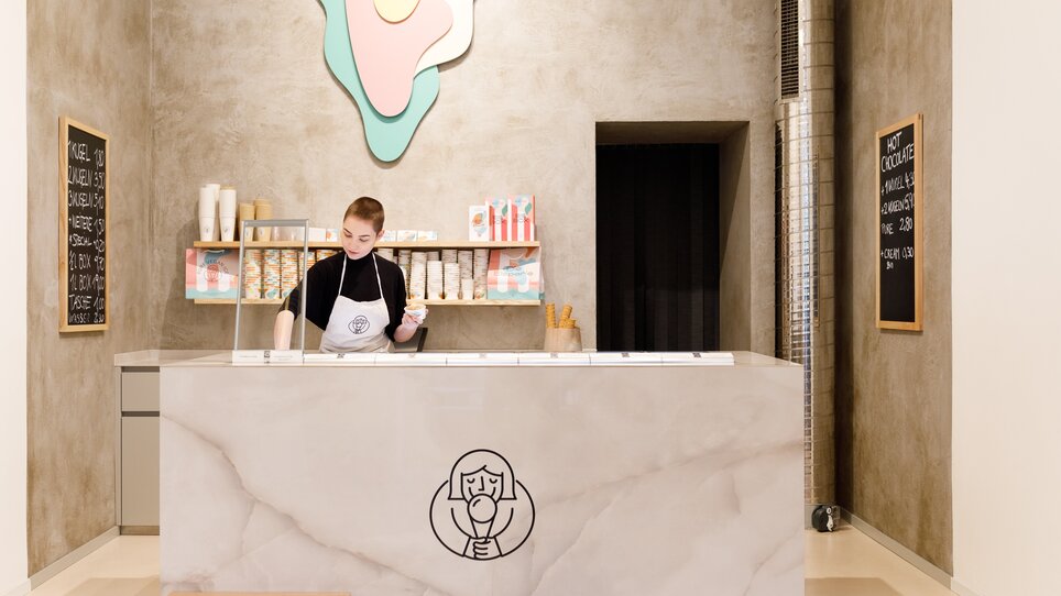 Moderne Eisdiele mit Theke und Mitarbeiterin in Graz. | © Eisperle - Stiefkind Fotografie