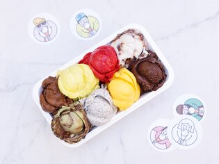 A variety of colorful ice cream scoops in a bowl with stickers. | © Eisperle - Stiefkind Fotografie