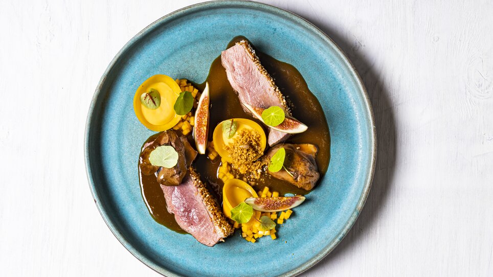 Un piatto splendidamente presentato con carne, frutta e salsa. | © Genießerei am Markt