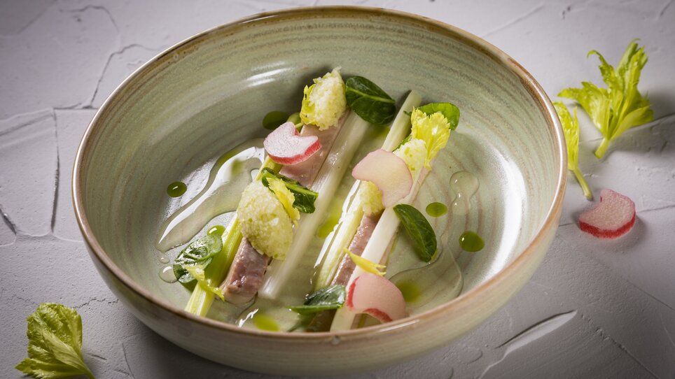 Piatto gourmet con pesce, verdure ed erbe in una ciotola elegante. | © Genießerei am Markt