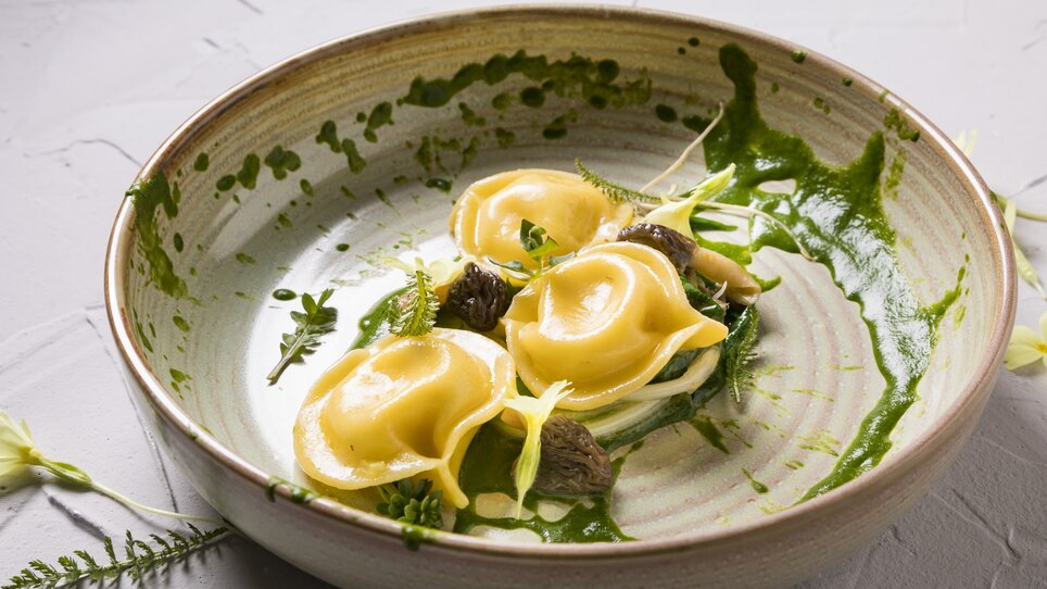 Ravioli fatti a mano con erbe e salse su un piatto. | © Genießerei am Markt