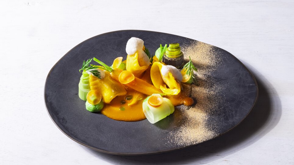 Un piatto artisticamente decorato con verdure colorate e salsa. | © Genießerei am Markt - Werner Krug