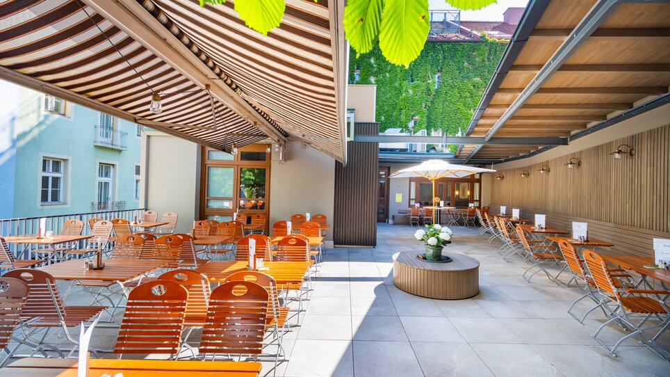 Cozy outdoor area of Gösser Bräu in Graz with wooden chairs and tables. | © Gösser Bräu Graz