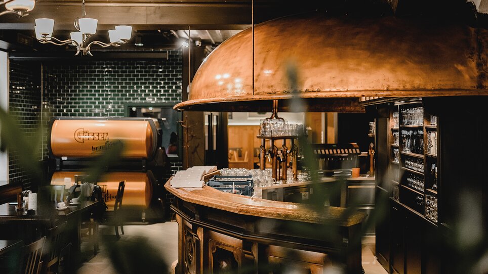 Cozy ambiance at Gösser Bräu Graz with bar and seating. | © Tina Szabo