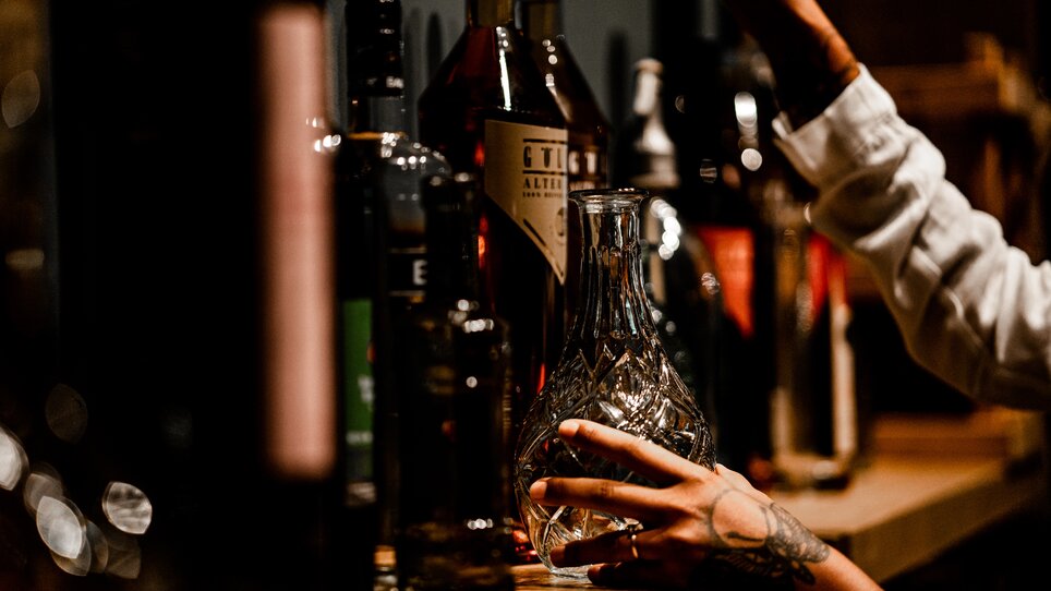 A beautifully decorated shelf featuring various spirits and a decanter. | © Tina Szabo