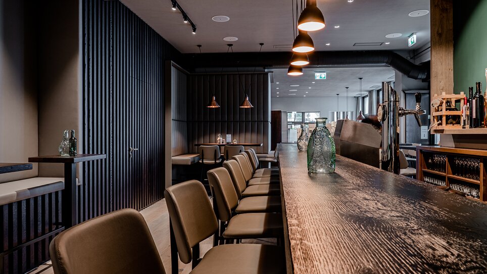 Modern bar with wooden counter and stylish lighting. | © Tina Szabo