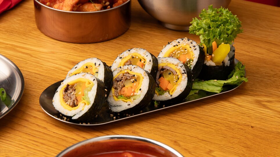 Ein Teller Sushi, Kimchi, gebratenes Hähnchen und Reis. | © Gogi KG
