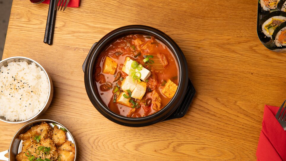 Schüsseln mit koreanischem Essen: Tofu-Suppe, Reis und Chicken. | © Gogi KG