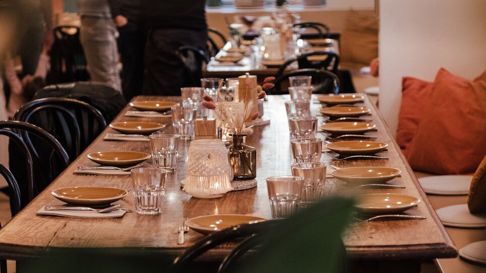 Un tavolo apparecchiato in un ristorante con bicchieri e piatti. | © Hummel