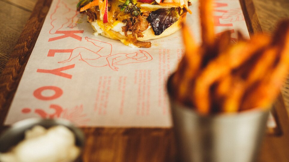 A delicious burger with sides in a restaurant. | © Aaron Jiang