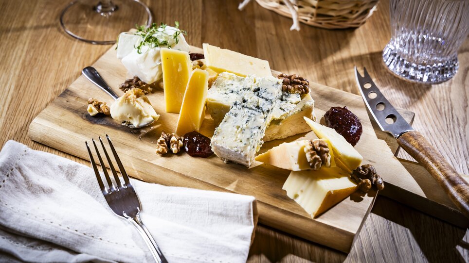 Un tagliere di legno con diversi formaggi, noci e marmellata. | © Kaiser Greissler - Werner Krug
