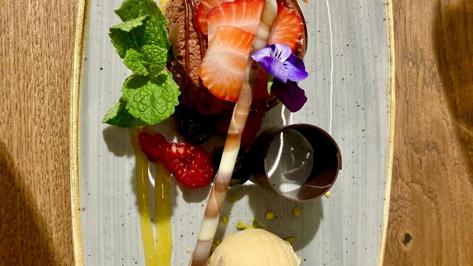 Dessert con torta al cioccolato, gelato, frutta e decorazione. | © PUR - die Kochschule Graz