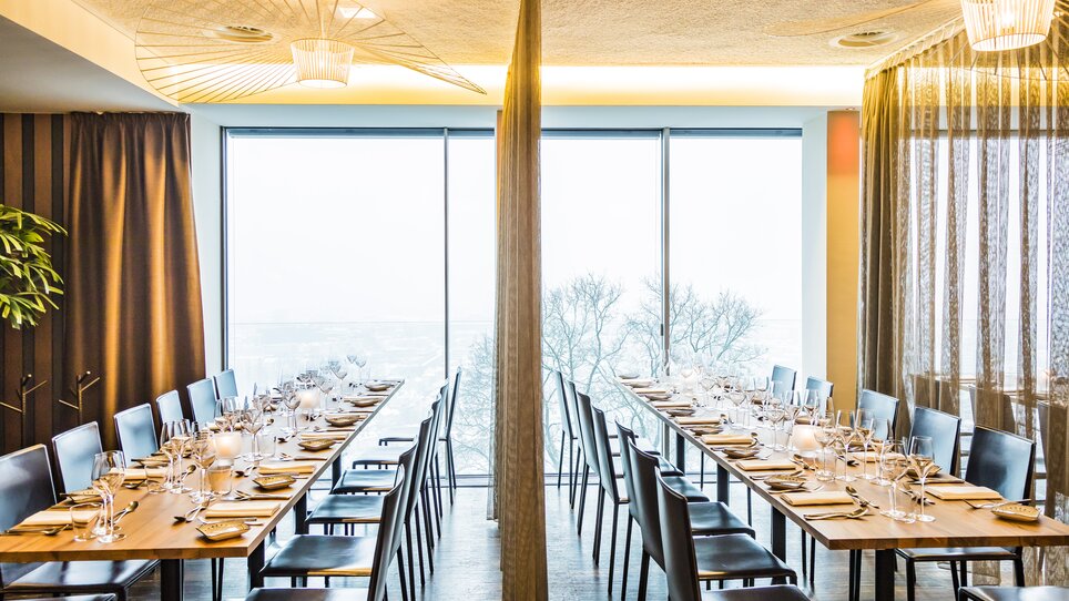 Moderne Restaurantansicht mit Tischdekoration und Panoramafenstern. | © Restaurant Schlossberg - Werner Krug