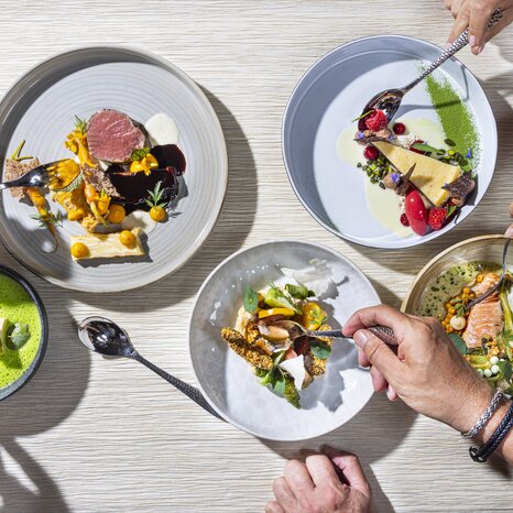 A table with various dishes and several forks. | © Werner Krug