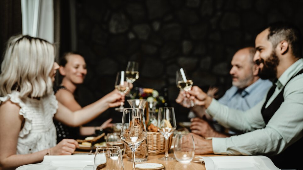 Friends toast with glasses at a table in Wirtshaus Thorbauer. | © Julian Wallner