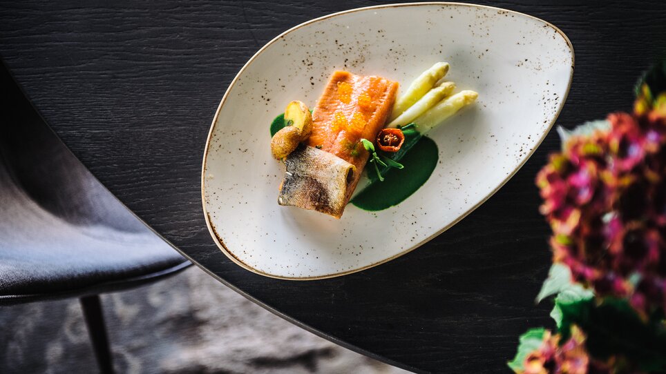 Ein kunstvoll angerichtetes Gericht mit Fisch und Gemüse. | © aiola - Joel Kernasenko