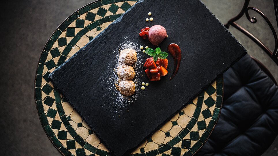 Köstliches Dessert auf schwarzem Schieferteller mit Früchten und Eis. | © aiola - Joel Kernasenko