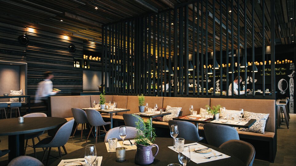 Moderne Restaurantansicht mit eleganten Tischen und Holzdekor. | © aiola - Joel Kernasenko
