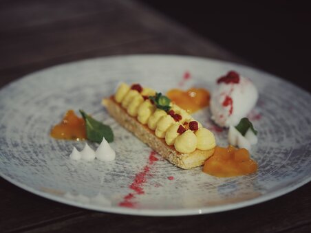 Delicious dessert with cream, fruit gels, and ice cream on a plate. | © aiola