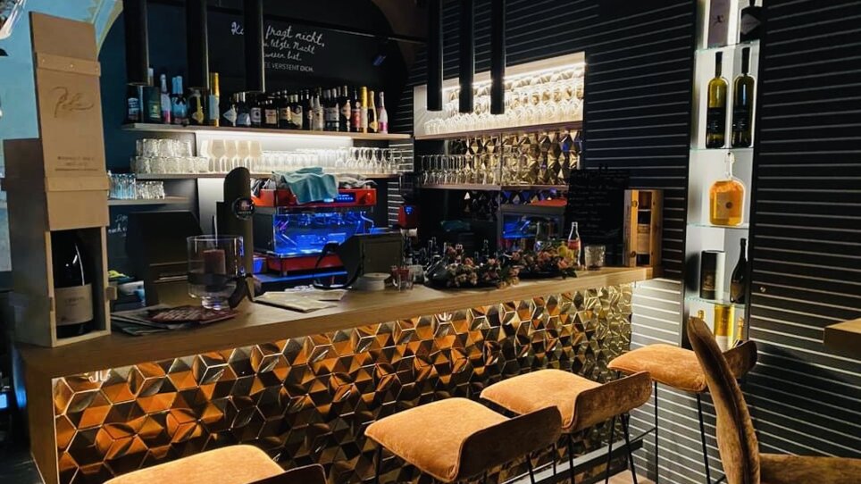 Modern bar with golden counter and drinks in Graz. | © Amaro