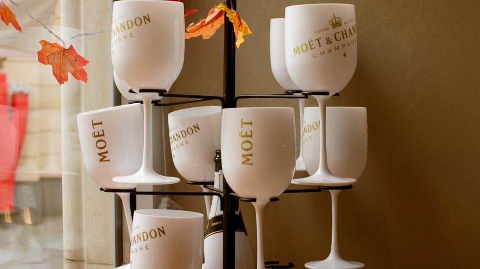 Decorative glasses with Moët & Chandon lettering in a café bar. | © Amaro