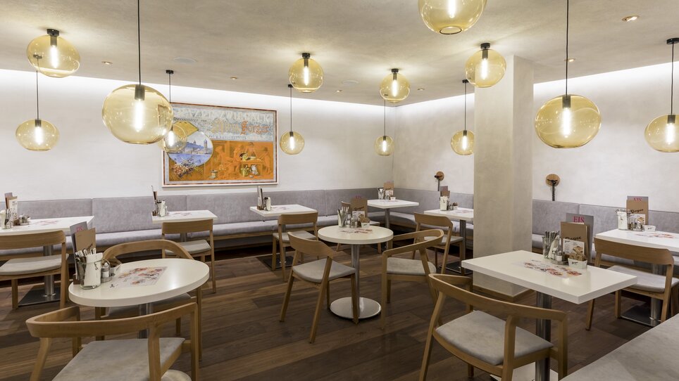 Moderne Restaurantansicht mit ovalen Lampen und Holzdetails. | © Werner Krug