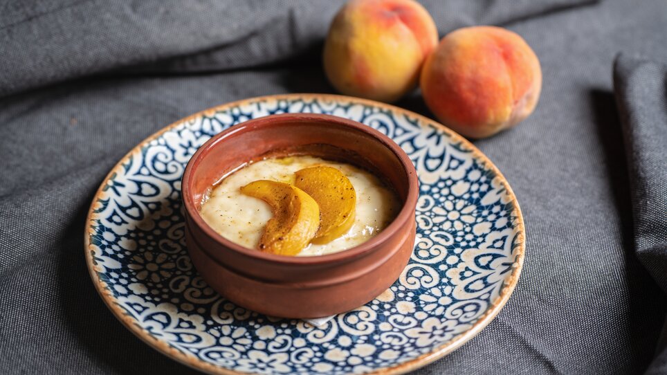 Eine Schüssel mit cremigem Dessert und Pfirsichscheiben. | © Muamer Gazibegovic