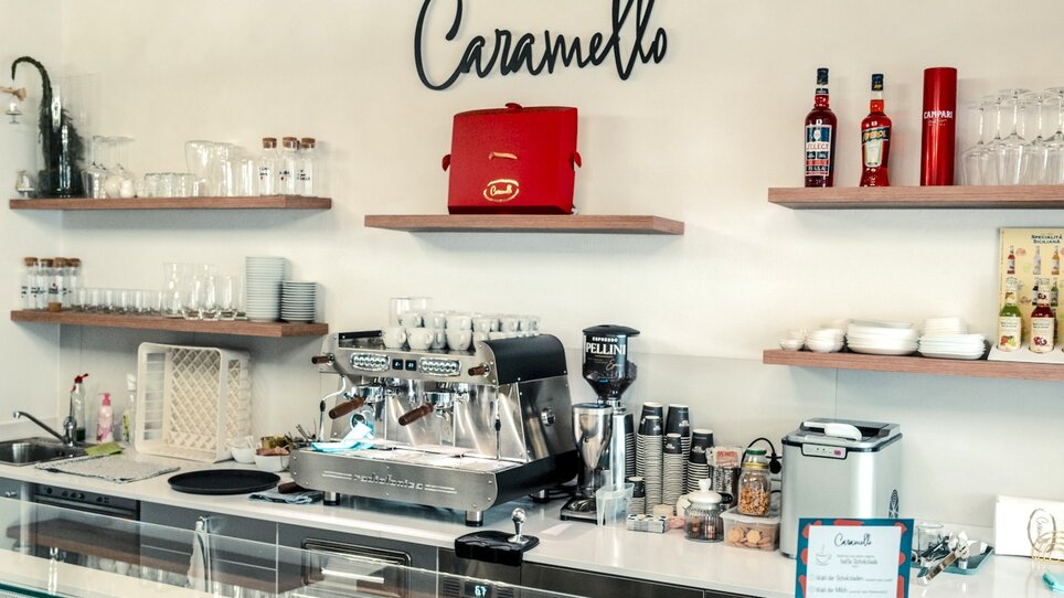 Vitrine eines Cafés mit Desserts und Kaffeemaschine. | © Bernd Grosseck