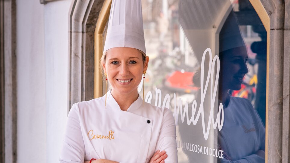 Köchin vor Caffè Caramello in Graz, sie trägt eine Kochjacke und eine Kochmütze. | © Bernd Grosseck