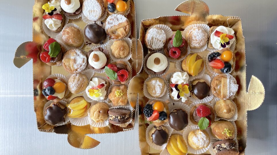 Leckereien in zwei Schachteln, gefüllt mit verschiedenen Gebäckstücken. | © Caramello Caffè