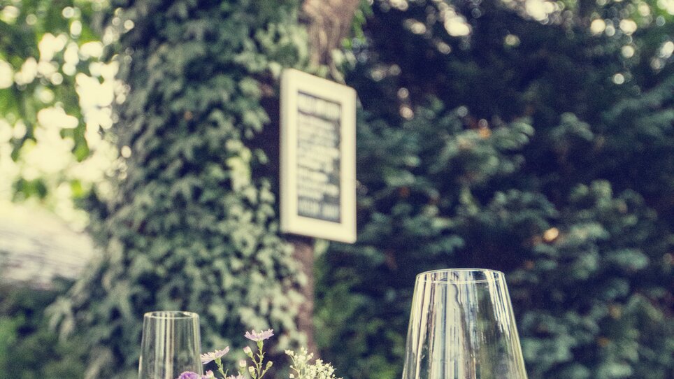 Ein stimmungsvolles Café mit Blumen und Gläsern auf einem Tisch. | © Cafe Fotter