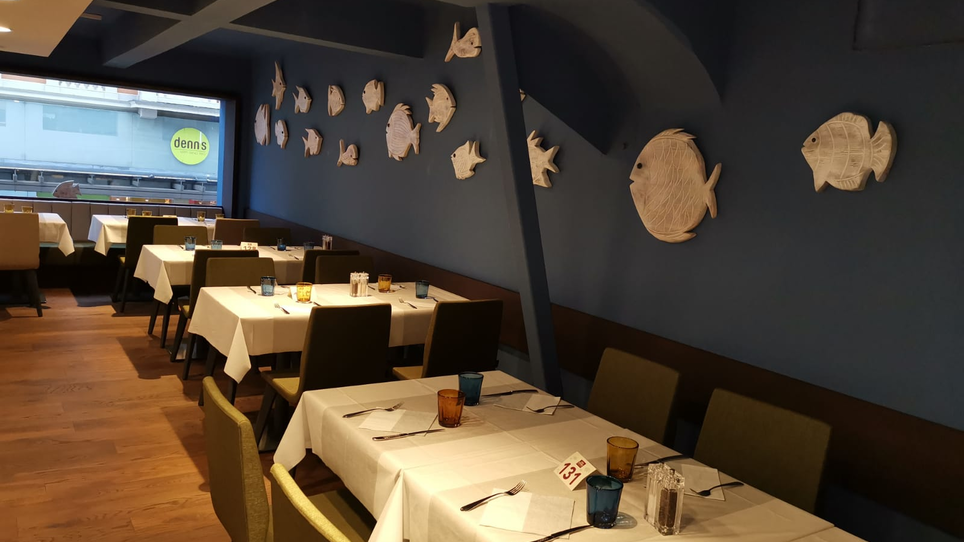 Blick ins Restaurant mit Fischdekorationen an der Wand. | © Casa Costiera