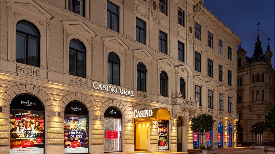 Das Casino Graz mit beleuchteten Eingängen bei Nacht. | © casinosaustria