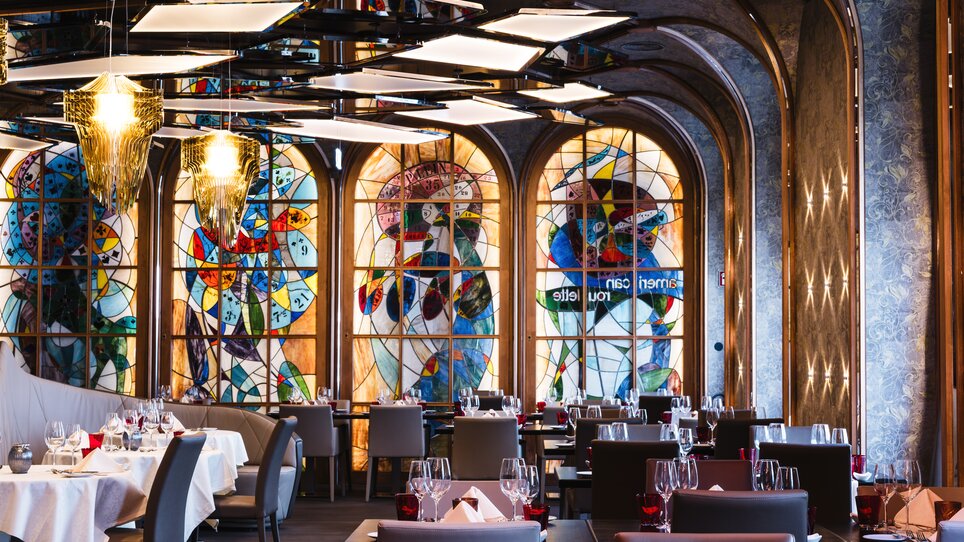 An elegant restaurant in Graz featuring colorful stained glass windows. | © Casino Graz