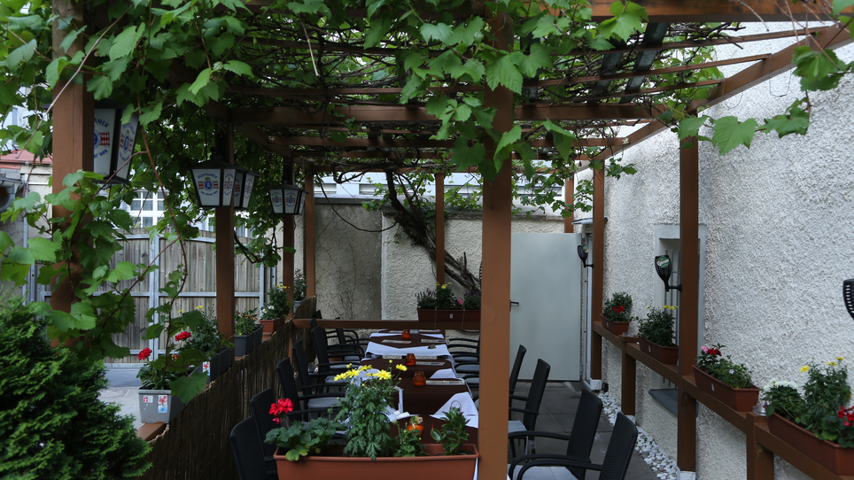 Accogliente area esterna con piante e tavoli a Graz. | © Ceylon Curry