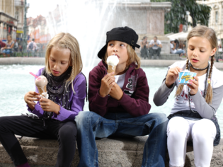Drei Kinder genießen Eis vor einem Brunnen in Graz. | © Graz Tourismus - Harry Schiffer